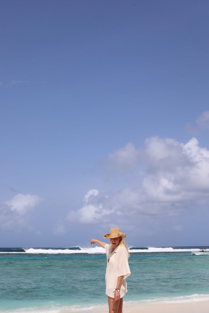 laura pointing at crystal blue water and surf in Maldives Club Med Kani